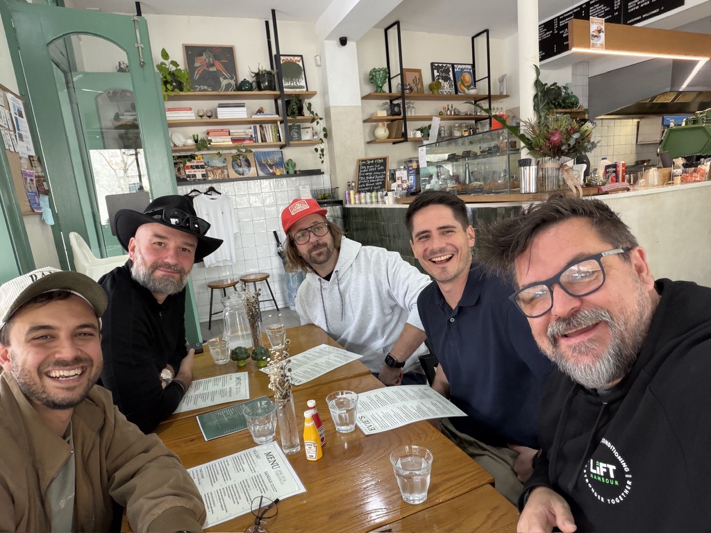 Five members around a cafe table at breakfast